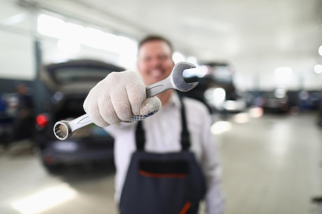 Chiave maschio della tenuta del riparatore nel primo piano dell'officina dell'automobile