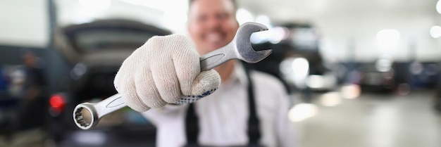 Chiave maschio della tenuta del riparatore nel primo piano dell'officina dell'automobile