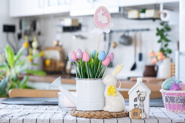 Chiave per la casa di una casa accogliente con decorazioni pasquali con coniglio e uova sul tavolo della cucina Progetto di progettazione edilizia trasferirsi in una nuova casa mutuo assicurazione affitto e acquisto di immobili