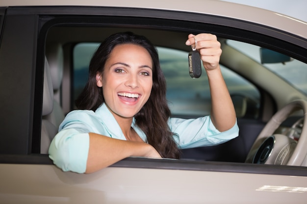 Chiave sorridente dell&#39;automobile della tenuta della donna