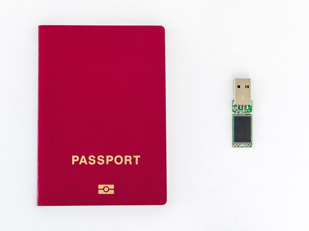 Chiavetta USB e passaporto rosso su sfondo bianco