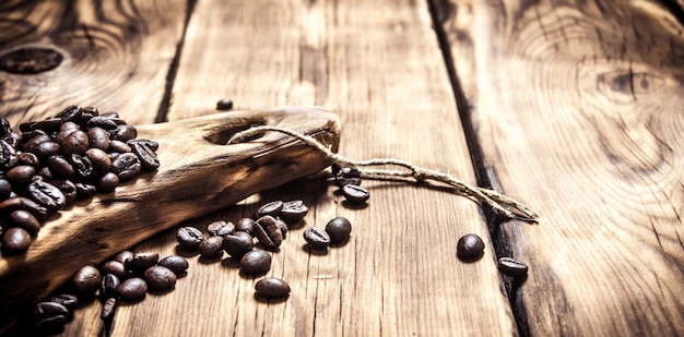 Chicchi di caffè aromatici freschi su una tavola di legno sulla tavola di legno.