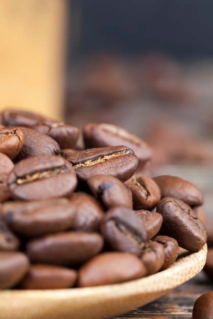 Chicchi di caffè aromatici in un cucchiaio di legno