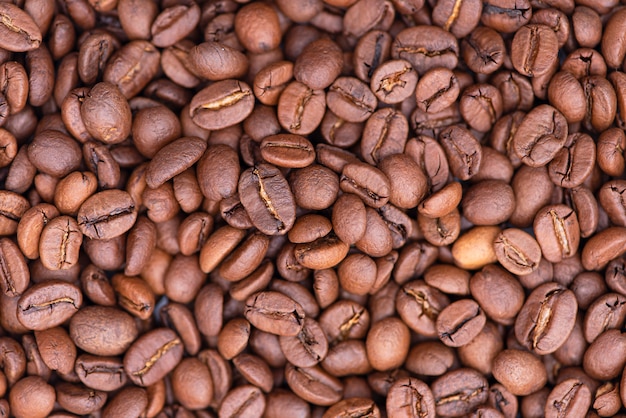 Chicchi di caffè arrostiti come fondo, primo piano, macro chicco di caffè, vista superiore
