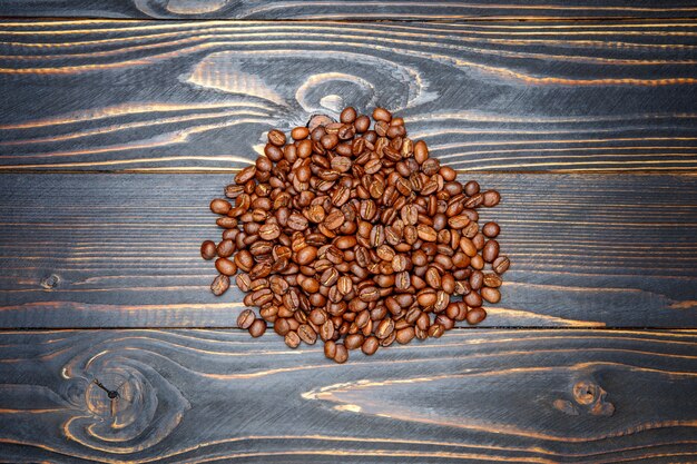 Chicchi di caffè arrostiti su fondo di legno