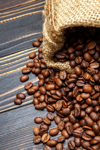 Chicchi di caffè arrostiti su fondo di legno