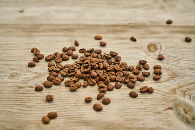 Chicchi di caffè arrostiti sul tavolo di legno