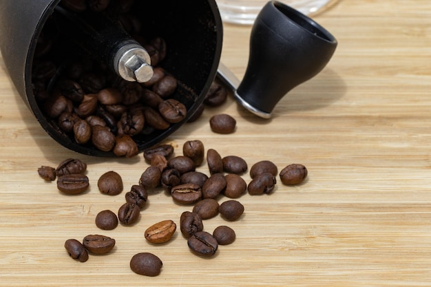 Chicchi di caffè caduti da un macinacaffè su legno chiaro