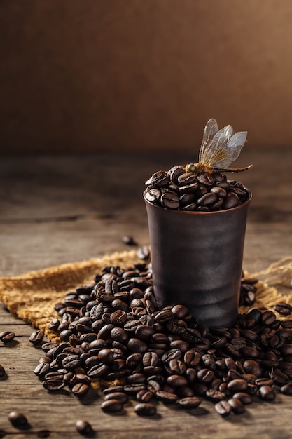 chicchi di caffè con la libellula su fondo in legno