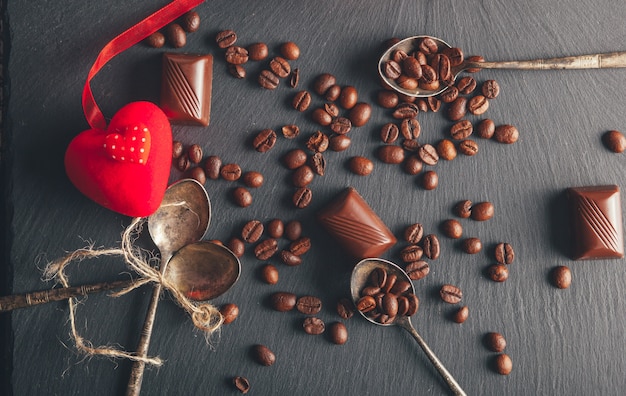 chicchi di caffè e dolci su sfondo nero