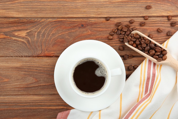 Chicchi di caffè e tazza di caffè su sfondo colorato con posto per il testo