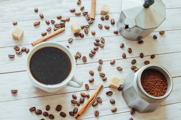 Chicchi di caffè e tazza di caffè sulla tavola sopra