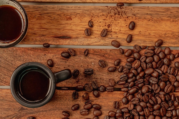 Chicchi di caffè e tazza su un vassoio e un tavolo di legno, decorazione della caffetteria