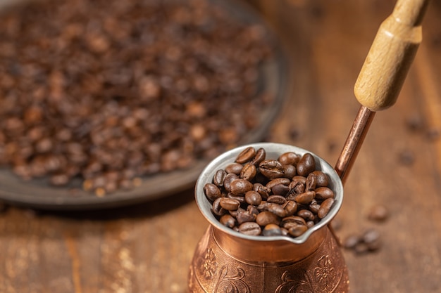 Chicchi di caffè in cezve di rame, concetto di caffè nero