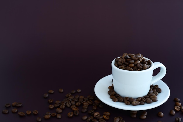 Chicchi di caffè in tazza di caffè su uno spazio marrone della copia del fondo