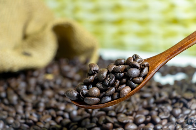 Chicchi di caffè in un cucchiaio di legno