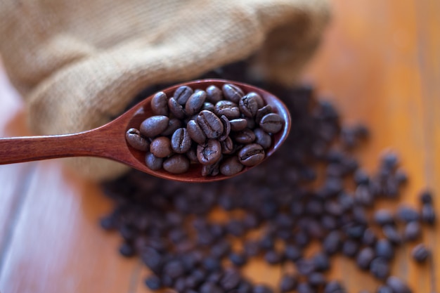 Chicchi di caffè in un cucchiaio di legno