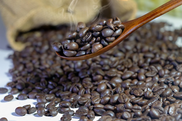 Chicchi di caffè in un cucchiaio di legno