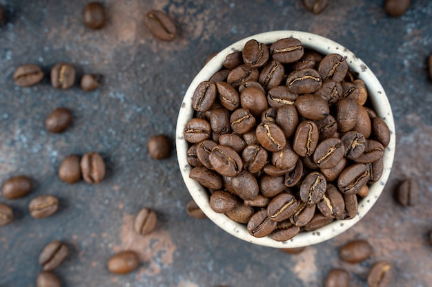 Chicchi di caffè in una ciotola di ceramica.