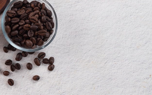 Chicchi di caffè in una mini ciotola di vetro con fotografia piatta