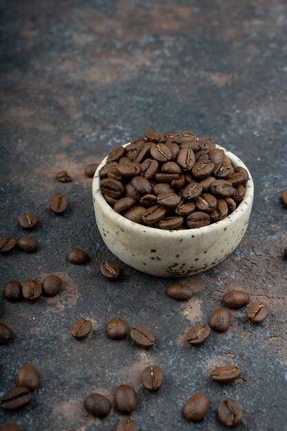 Chicchi di caffè in una tazza, chicchi di caffè sparsi.