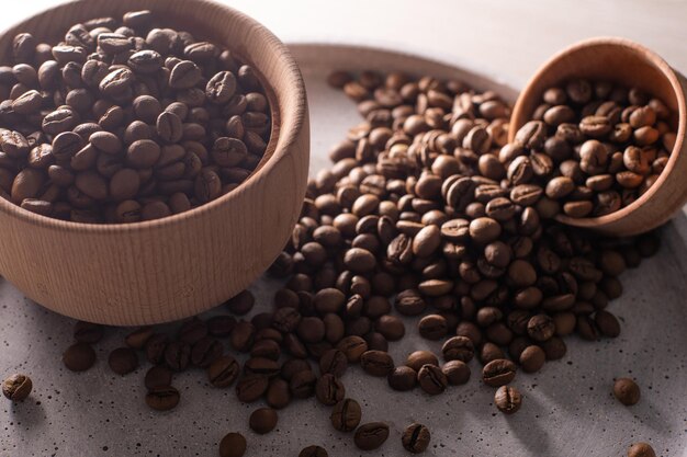 Chicchi di caffè in una tazza di legno.