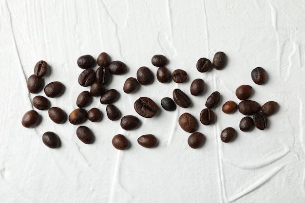 Chicchi di caffè su sfondo bianco, vista dall'alto e spazio per il testo