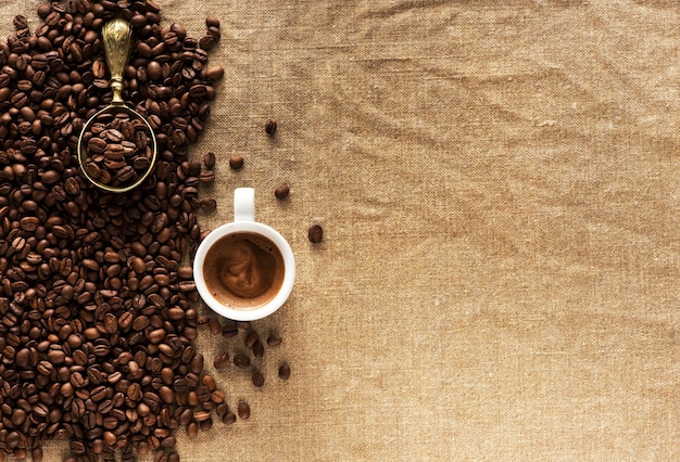 Chicchi di caffè su tela e tazza di caffè. Sfondo di caffè