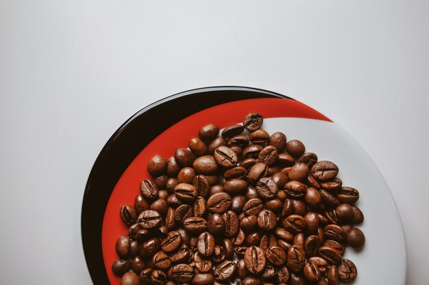 Chicchi di caffè su un piatto isolato su uno sfondo bianco elaborazione di foto d'epoca