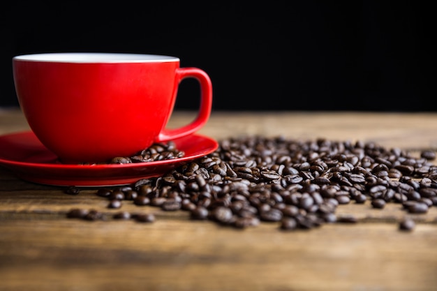 Chicchi di caffè su un tavolo con tazza