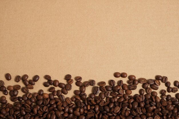 Chicchi di caffè su uno sfondo di cartone, copia dello spazio.