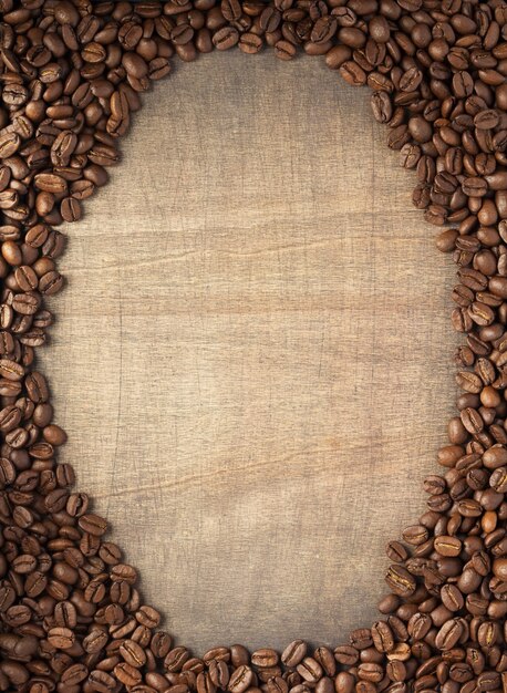 Chicchi di caffè sul fondo del tavolo in legno, vista dall'alto