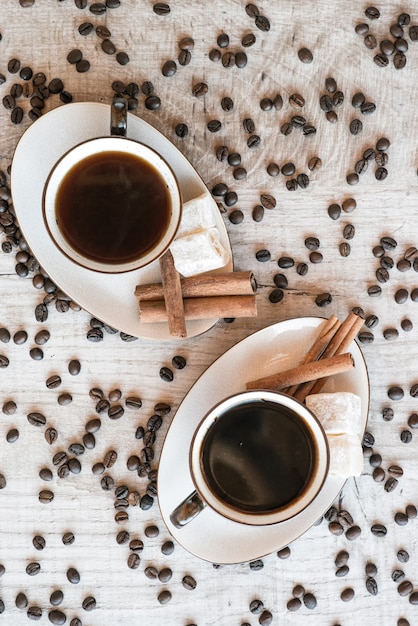 Chicchi di caffè sulla tavola di legno con dolci e croissant