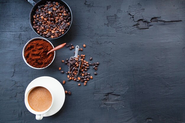 Chicchi di caffè tostati con polvere di caffè e tazze di caffè.