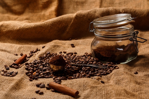 Chicchi di caffè tostati e scoop con caffè macinato