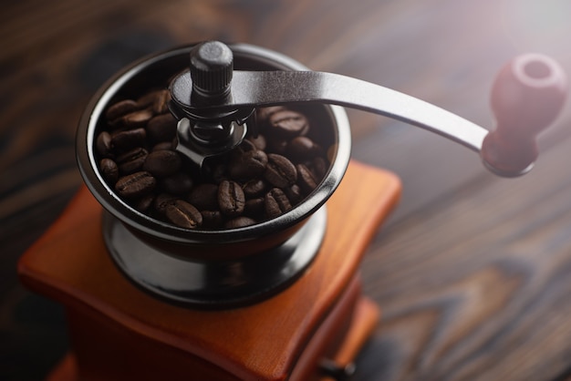 Chicchi di caffè tostati in un macinino da caffè. Preparare il caffè per la preparazione.