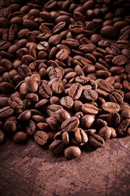 Chicchi di caffè tostati isolati da vicino su sfondo marrone grunge