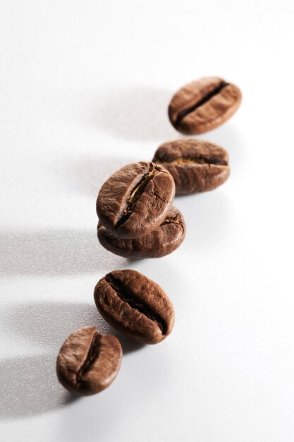 Chicchi di caffè tostati isolati da vicino su un tracciato di ritaglio di sfondo bianco