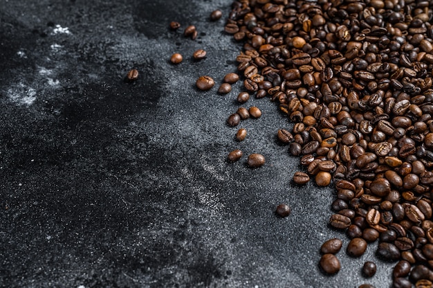 Chicchi di caffè tostati sulla tavola rustica.