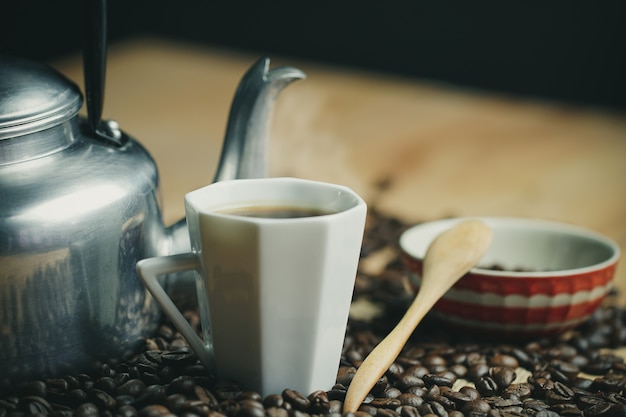 Chicchi di caffè tostato e tazza di caffè caldo.