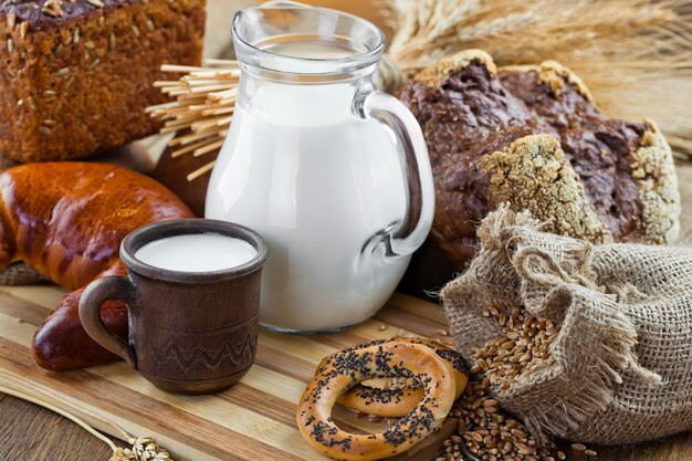 Chicchi di grano e pane su un fondo di legno