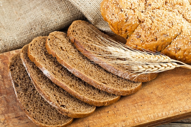 Chicchi di grano e pane su un fondo di legno