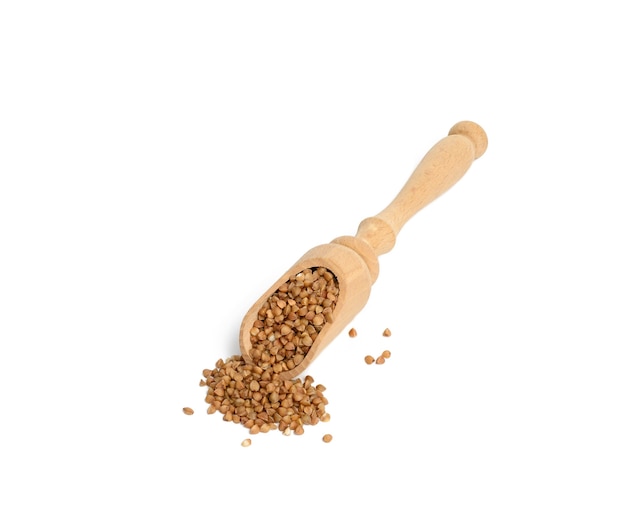 Chicchi di grano saraceno crudo in cucchiaio di legno isolato, vista dall'alto