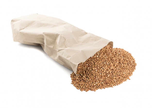 Chicchi di grano saraceno crudo secco in confezione di carta isolato su sfondo bianco.