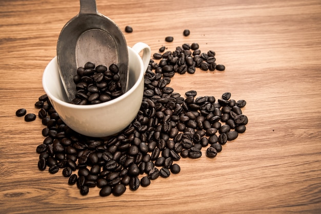 Chicchi e tazza di caffè su fondo di legno