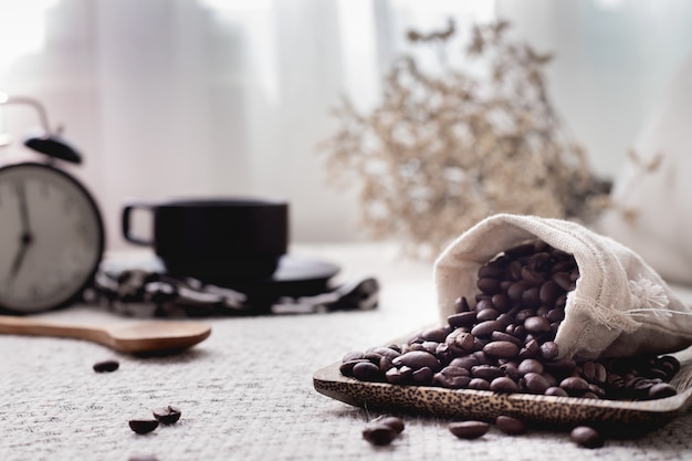 Chicco di caffè e tazza di caffè sulla tavola.