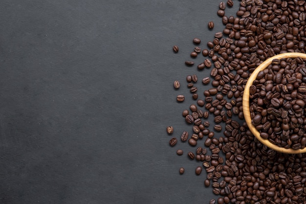 Chicco di caffè su fondo di legno nero del pavimento. vista dall'alto. spazio per il testo