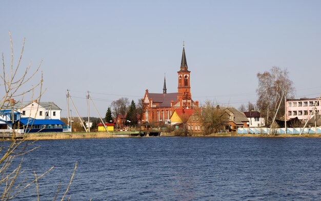 Chiesa cattolica di mattoni rossi sulla riva del fiume