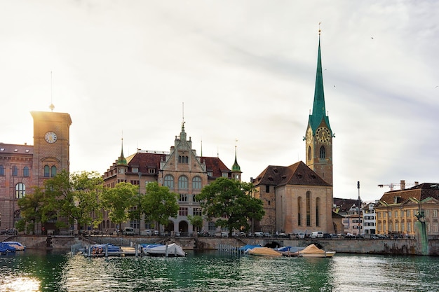 Chiesa di Fraumunster e barche molo del fiume Limmat nel centro della città di Zurigo, Svizzera. Persone sullo sfondo