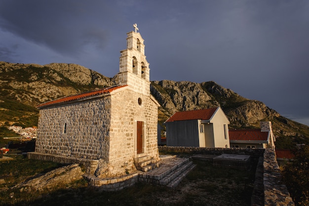 Chiesa di pietra europea sulla montagna nel tramonto